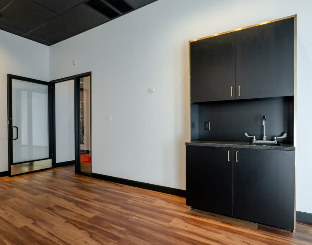 Move-in-ready private salon suite with cabinetry and styling setup