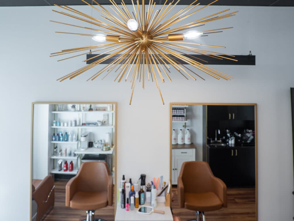 Private Cosmo Salon Studios suite interior with styling stations and warm architectural lighting
