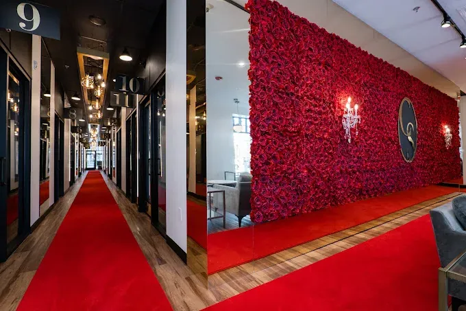 Numbered suite hallway and red rose wall in the lobby at Cosmo Salon Studios Dearborn